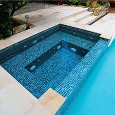 an empty swimming pool with steps leading up to the bottom and blue tiles on the floor