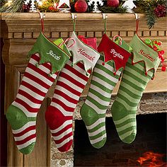 christmas stockings hanging from a mantel in front of a fireplace