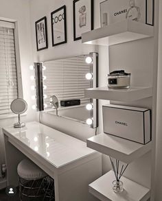 a white vanity with lights on it and a mirror in front of the counter top