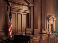 an empty courtroom with the american flag hanging on the wall