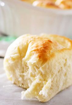 a close up of a piece of bread in front of a bowl with other food