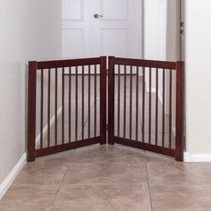 two wooden gates open in front of a white door and tiled floor with beige walls