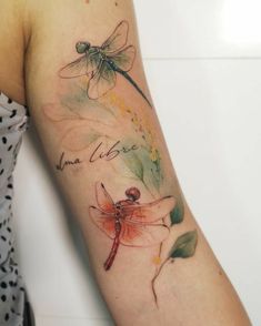 a woman's arm with a dragonfly tattoo on the left side of her arm