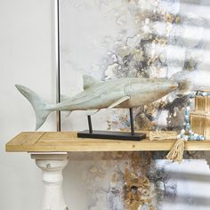 a sculpture of a shark on a wooden shelf