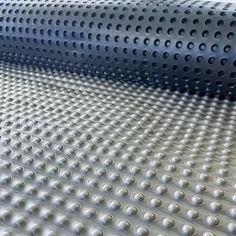 an array of white and black circles on a sheet of plastic material that looks like perforated metal