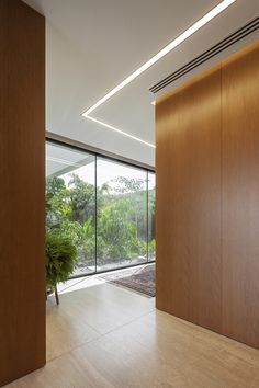 an empty room with wood paneling and glass doors leading to the outside patio area