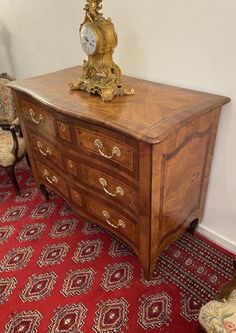 an ornate wooden dresser with a clock on top