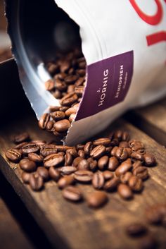 coffee beans spilling out of a bag onto a wooden table