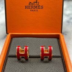 Hermes Gold Lacquered Pop H Earrings Red Euc Size Width: 0.25 In Height: 0.25 In This Is An Authentic Pair Of Hermes Gold Lacquered Pop H Earrings In Orange. These Stunning Hoop Earrings Are Crafted Of A Gold Plated Looping Hermes H With Red Lacquer For A Bold Accent To Your Ensemble, Only From Hermes! Excellent Condition Sanitized , Only Blemish On One Of The Backings A Bit Tarnish , You Can See On Photos Otherwise Perfect Authentic So Classy Comes With Box! Open To Offers And Bundles H Earrings, Hermes Jewelry, Red Lacquer, Earrings Red, Jewelry Earrings, Hoop Earrings, Bundles, Women Jewelry, Orange