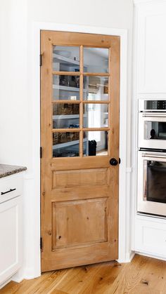 a kitchen with an oven and wooden door