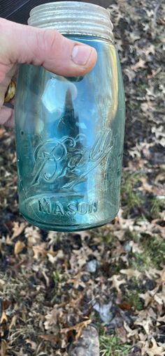 a person holding a mason jar in their hand