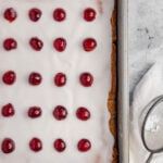 a cookie sheet with cherries on it next to a pair of scissors