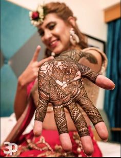 a woman is showing off her henna