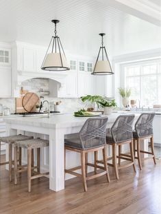 a kitchen island with four stools in front of it