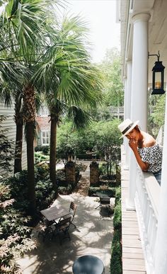 a woman is sitting on the porch talking on her cell phone