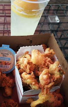 a box filled with fried food next to a drink