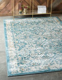 a blue and white area rug in front of a wooden wall