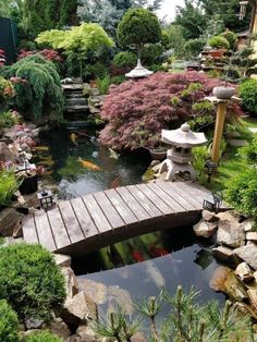 a wooden bridge over a small pond in a garden