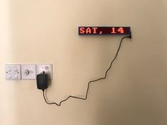 an electrical outlet with the time displayed on it's side and wires connected to plugs