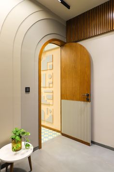 the entrance to an office building with a wooden door and plant on a small table