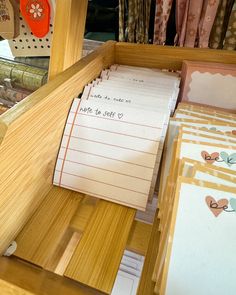 a wooden desk topped with lots of papers and post - it notes on top of each other