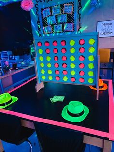 a table topped with neon colored plates and a board game on top of the table