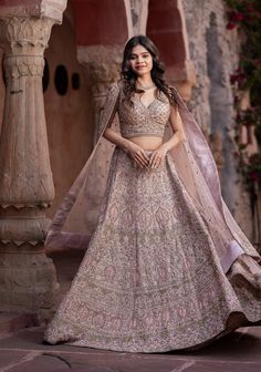 Item: Lehenga Set ( Lehenga Skirt, Blouse and Dupatta) Be the picture of elegance in our Dusty Rose Lehenga. Handcrafted with love and attention to detail, this ethereal ensemble is sure to make you feel like royalty on your wedding day. The delicate pink hue and intricate embroidery create a romantic and timeless look that is simply enchanting. With customization options available, you can tailor this lehenga to suit your unique style and preferences, ensuring you look and feel like a true princess as you walk down the aisle. This ensemble has been meticulously crafted in premium net fabric with cutdana and pearl embellishments, making it one of a kind.  Our bespoke lehengas are designed with a can-can lining beneath the skirt to ensure a voluminous silhouette that enhances your twirls an Rose Gold Lehenga, Lehenga Choli Designs, Gold Lehenga, Indian Wedding Gowns, Special Occasion Gowns, Skirt Blouse, Lehenga Skirt, Designer Lehenga Choli, Net Fabric