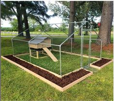 a chicken coop in the middle of a grassy area with steps leading up to it