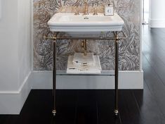 a white sink sitting under a mirror next to a wall mounted faucet in a bathroom