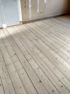 an empty room with wooden floors and white doors