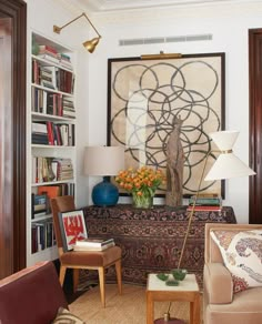 a living room filled with furniture and bookshelves next to a painting on the wall