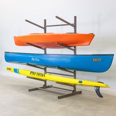 two kayaks and one surfboard are on display