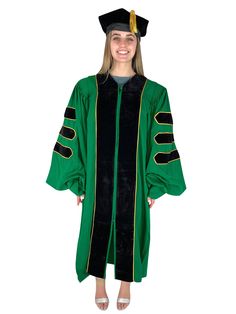 a girl in a green graduation gown and cap is smiling at the camera while standing with her hands on her hips