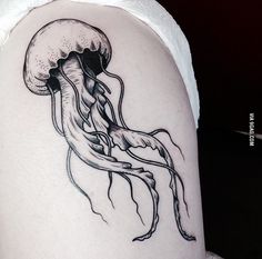 a black and white image of a jellyfish on the back of a woman's arm