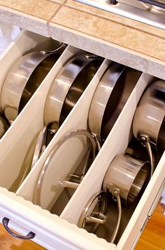 an open drawer filled with pots and pans