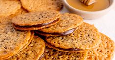 a pile of crackers sitting next to a cup of honey