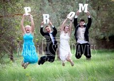 three people jumping in the air holding up letters