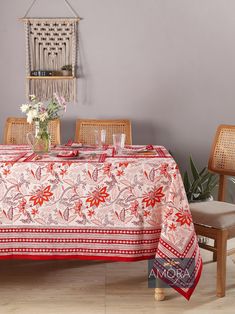 a dining room table with a red and white table cloth on it next to two chairs