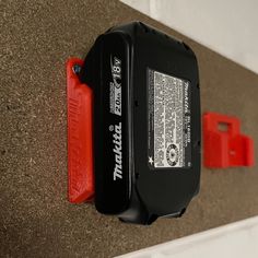 a black and red device mounted to the side of a wall