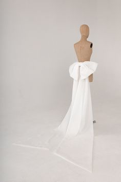 a mannequin wearing a white dress with a bow on it's back