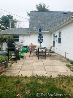 an outdoor patio with chairs and grill in the back yard