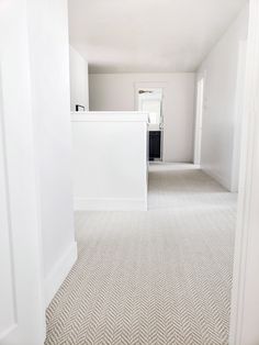 an empty room with white walls and carpeting on the floor is seen in this image