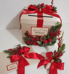 two boxes with red bows and pine cones on them