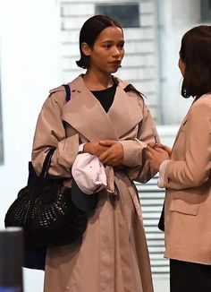 two women standing next to each other talking