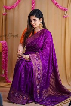 a woman in a purple sari sitting down