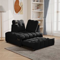 a black couch sitting on top of a rug in a living room