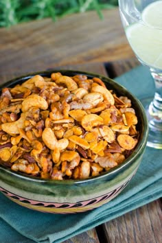 a bowl filled with nuts next to a glass of water