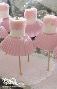 some pink cupcakes with white frosting on them