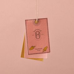 two tags hanging from strings on a pink background