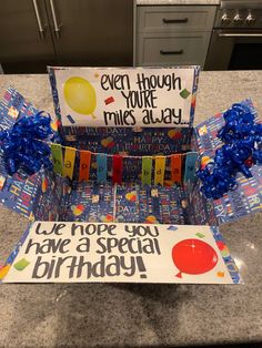 a birthday card holder made out of wrapping paper and some blue streamers on the counter